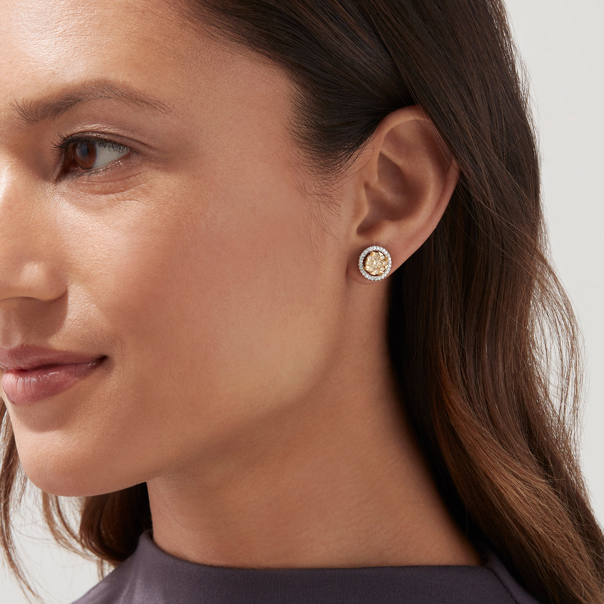 The Canare 14K Two Tone Gold Yellow Diamond Bouquet Halo Earrings feature a classic round design with a yellow diamond center and a halo of clear stones, totaling 0.98 carats.