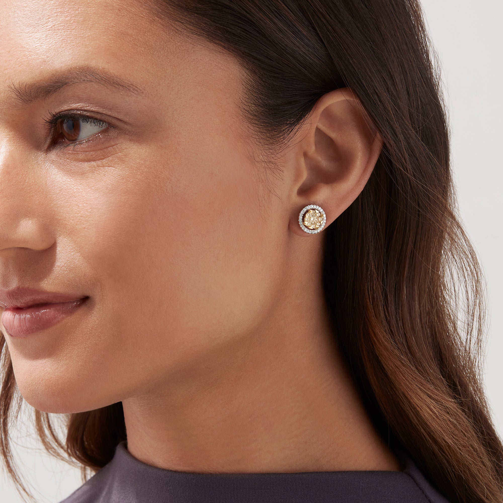 The Canare 14K Two Tone Gold Yellow Diamond Bouquet Halo Earrings feature a classic round design with a yellow diamond center and a halo of clear stones, totaling 0.98 carats.