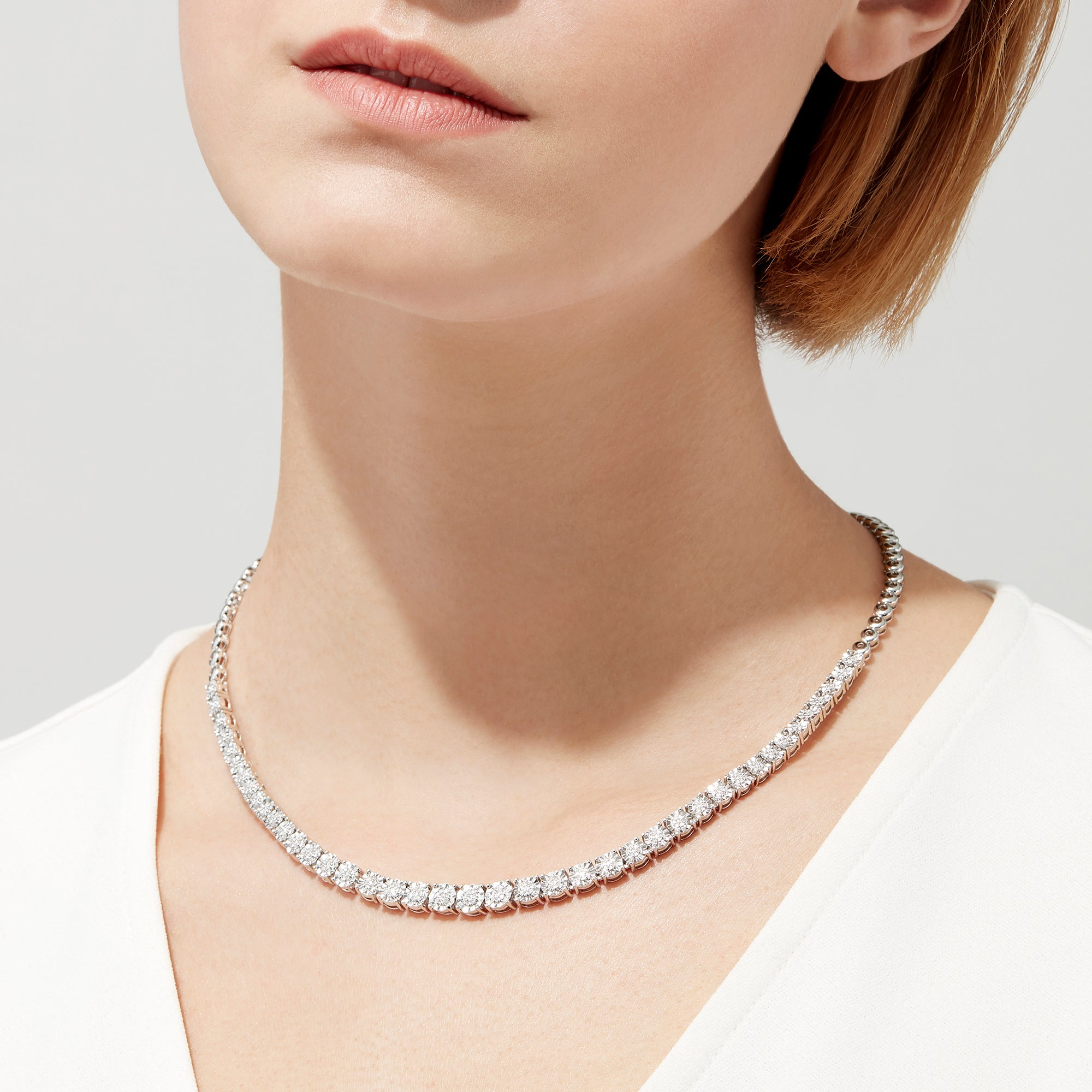 A 925 Sterling Silver Diamond Necklace, 0.31 TCW, showcases a continuous row of round white diamonds in a classic tennis style on a plain white background. Total carat weight available upon request.