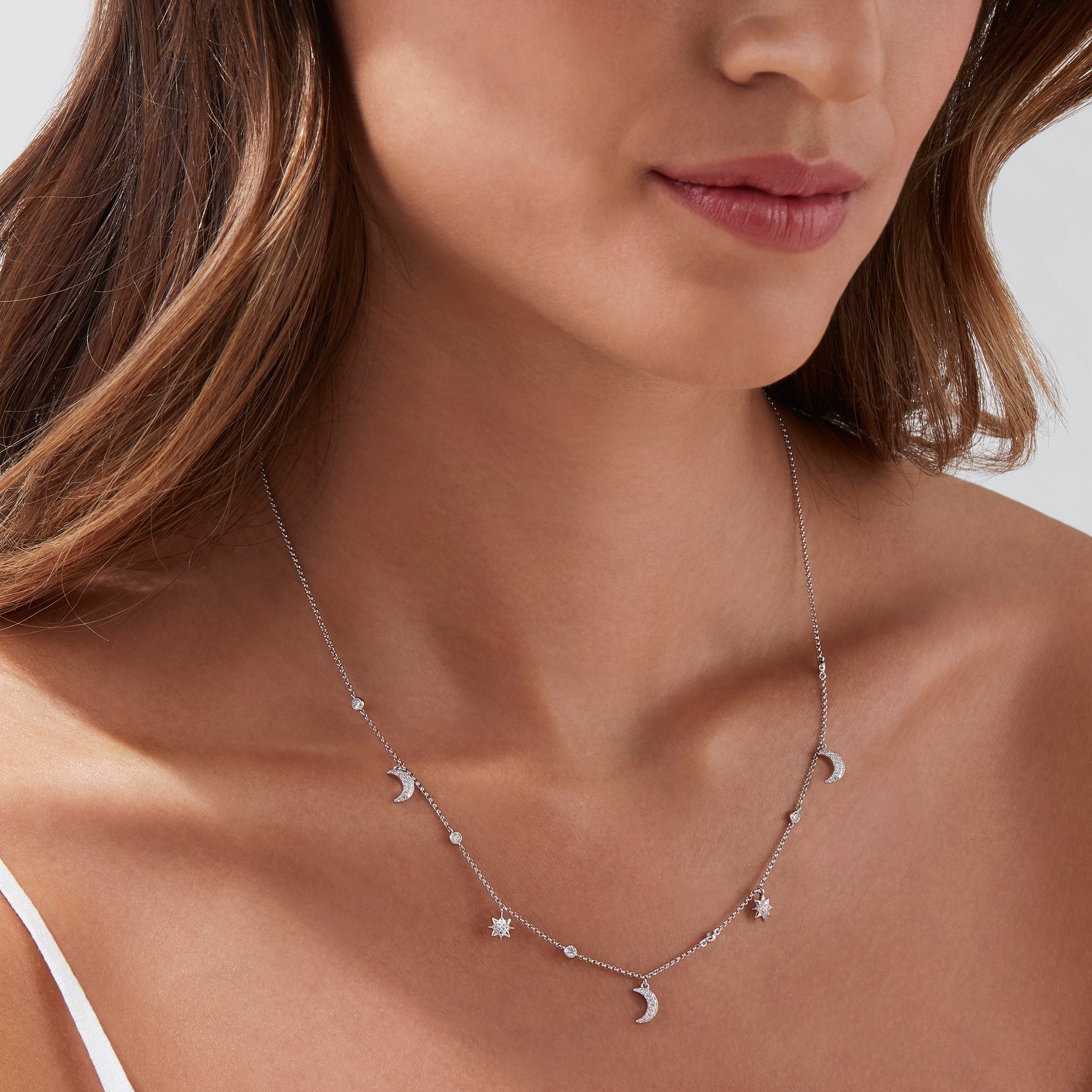 The Novelty 14K White Gold Diamond Moon and Stars Necklace, 0.38 TCW, features a crescent moon pendant and two star charms with sparkling diamonds, all elegantly set on a white gold chain for a celestial-inspired look.