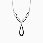 The 14K White Gold Black and White Diamond Necklace, 1.46 TCW, features an abstract teardrop pendant with intertwining black and silver loops, adorned with sparkling black and white diamonds.