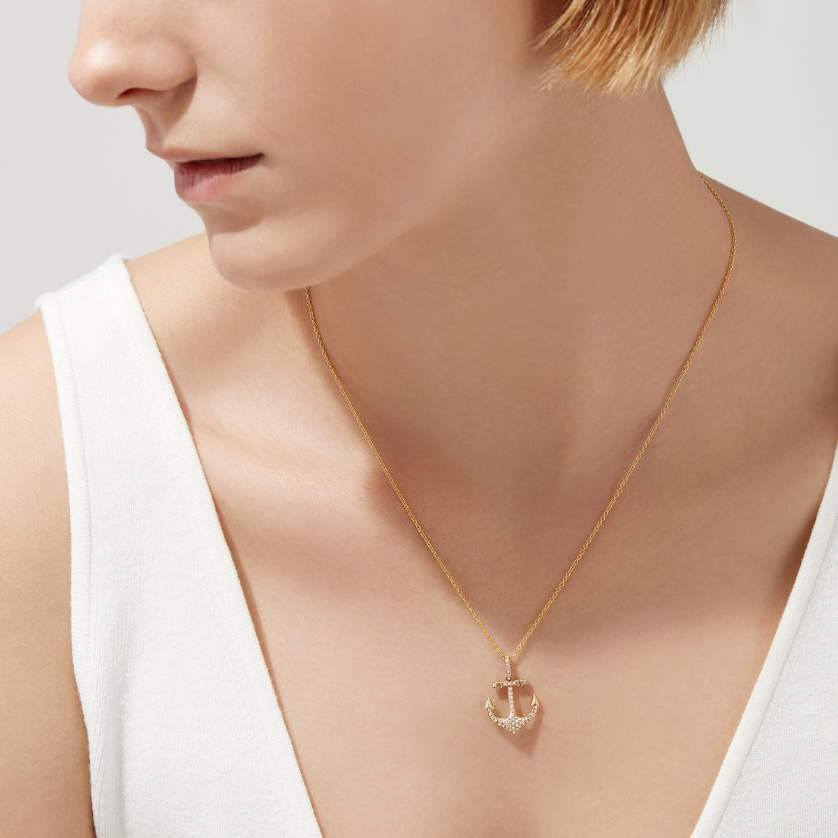 The Seaside 14K Yellow Gold Diamond Anchor Pendant (0.21 TCW) features sparkling diamonds and gold detailing at the tips and crossbar, creating a radiant anchor design against a plain white background.