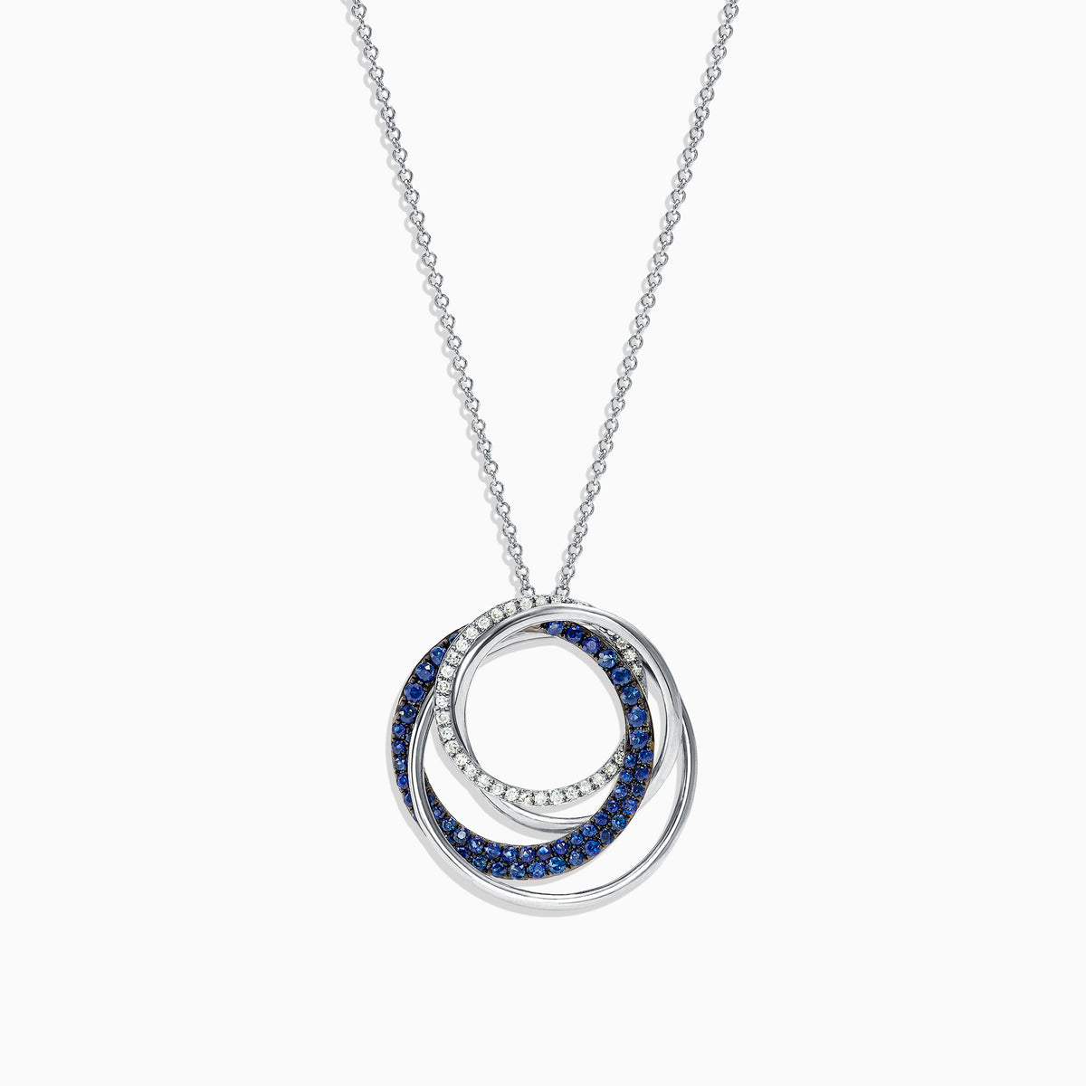 A 14K white gold necklace showcases a pendant of two interlocking circles—one with blue sapphires, the other with diamonds (0.74 TCW)—suspended from a delicate chain on a white background.