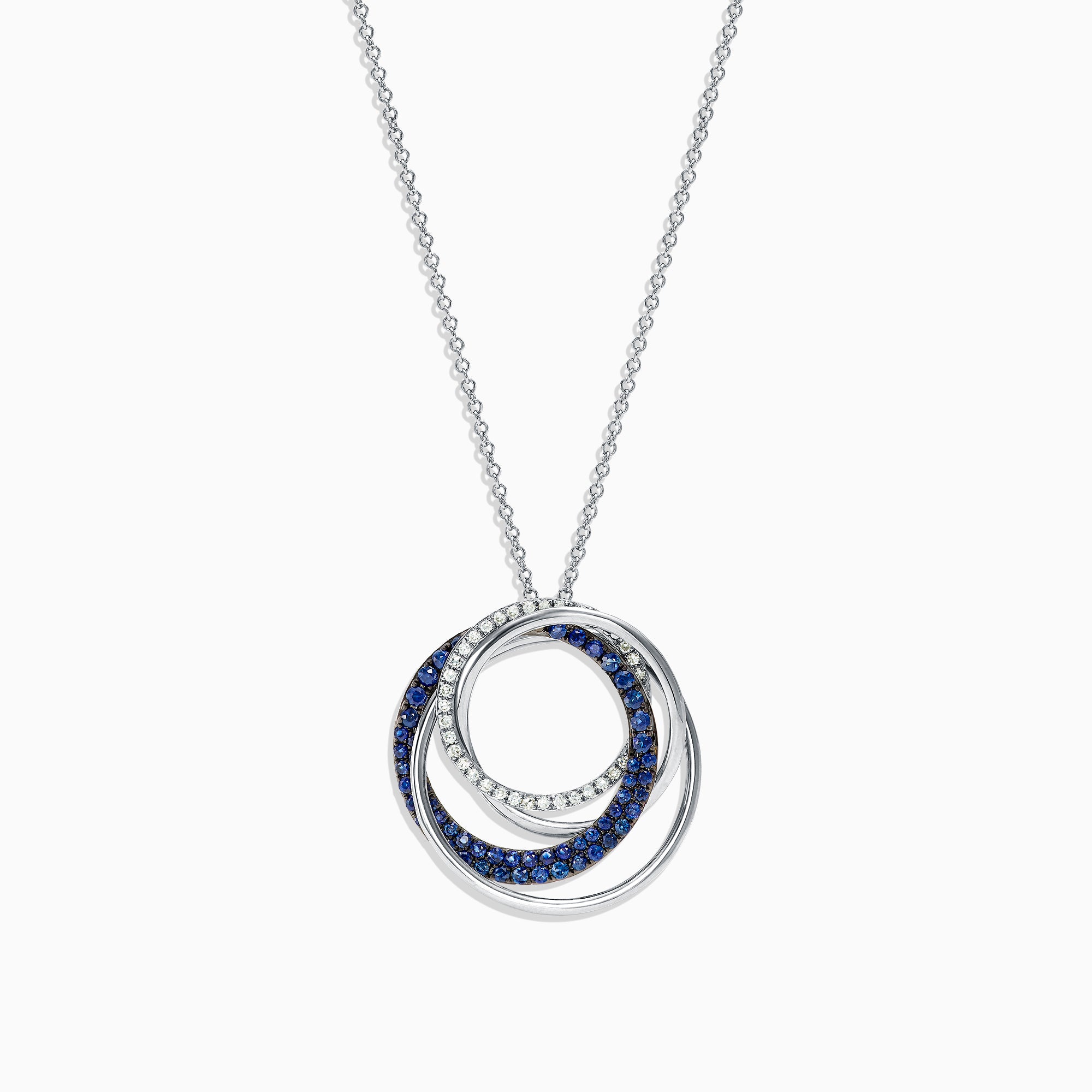A 14K white gold necklace showcases a pendant of two interlocking circles—one with blue sapphires, the other with diamonds (0.74 TCW)—suspended from a delicate chain on a white background.
