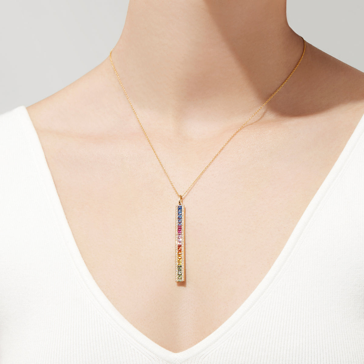 The Watercolors 14K Yellow Gold Sapphire and Diamond Vertical Pendant (2.06 TCW) features a row of rainbow gradient gemstones, accented by sapphires and diamonds, hanging from a delicate gold chain against a white background.