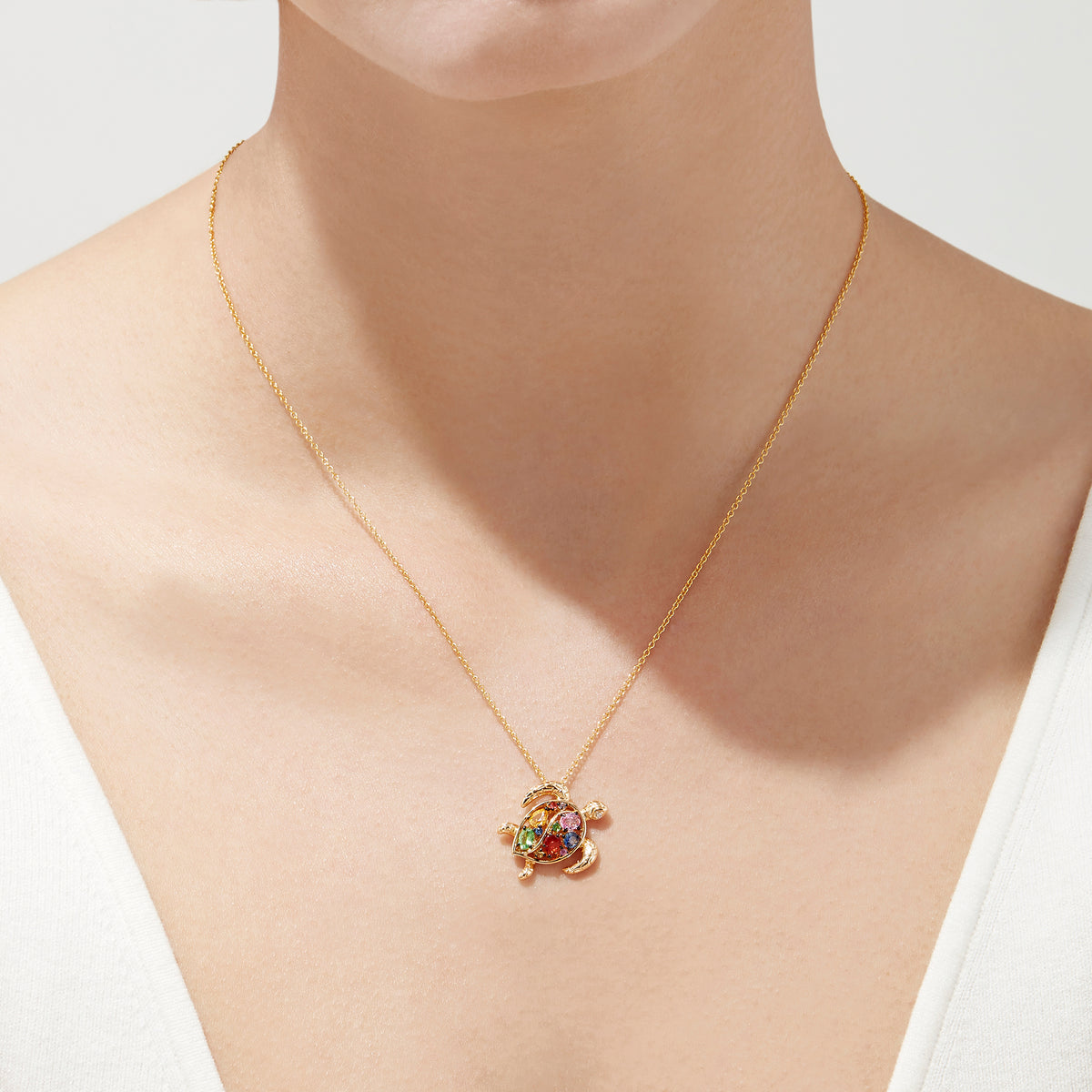 The Watercolors 14K Gold Sapphire & Diamond Turtle Pendant (0.99 TCW) features a gold turtle with a colorful gemstone shell and sparkling sapphire, suspended from a delicate gold chain, shown against a white background.