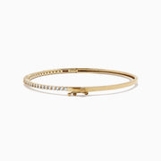 The DOro 14K Yellow Gold Diamond Bangle, 1.00 TCW features a slim design with a single row of sparkling white diamonds on the top curve, beautifully showcased against a white background.