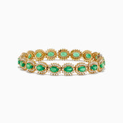 The 14K Yellow Gold Emerald and Diamond Tennis Bracelet showcases oval emeralds framed by diamonds in a classic tennis bracelet design.