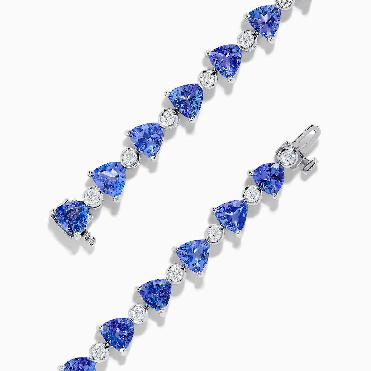 The Nahla 14K White Gold Tanzanite and Diamond Tennis Bracelet features alternating triangular tanzanite stones and round diamonds in a delicate, repeating pattern against a plain white backdrop.