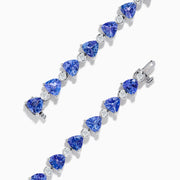 The Nahla 14K White Gold Tanzanite and Diamond Tennis Bracelet features alternating triangular tanzanite stones and round diamonds in a delicate, repeating pattern against a plain white backdrop.