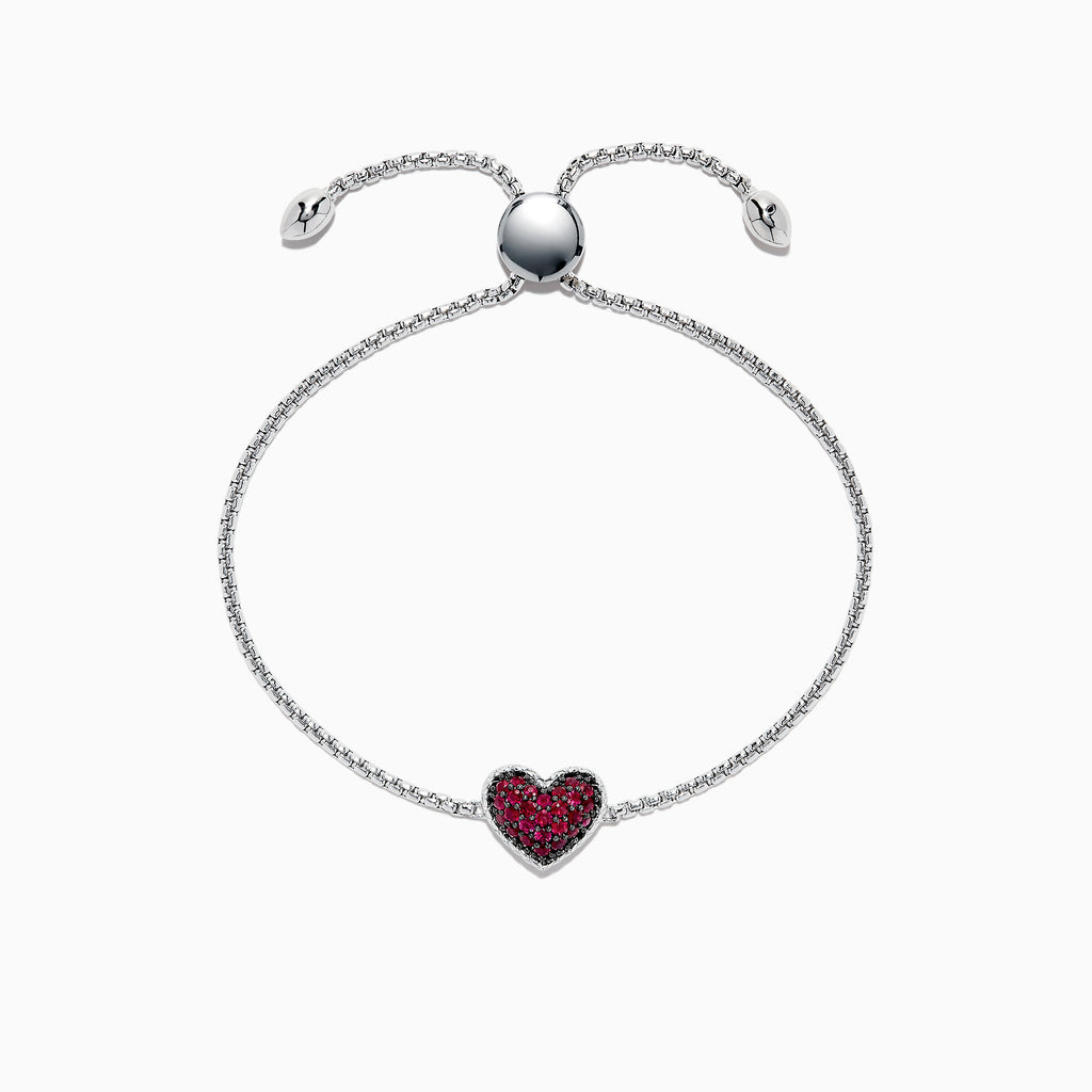 The 925 Sterling Silver Ruby Heart Bracelet, 0.62 TCW, features an adjustable clasp and a central heart-shaped charm accented with red stones. Small heart details at the ends add a touch of elegance to this beautiful piece.