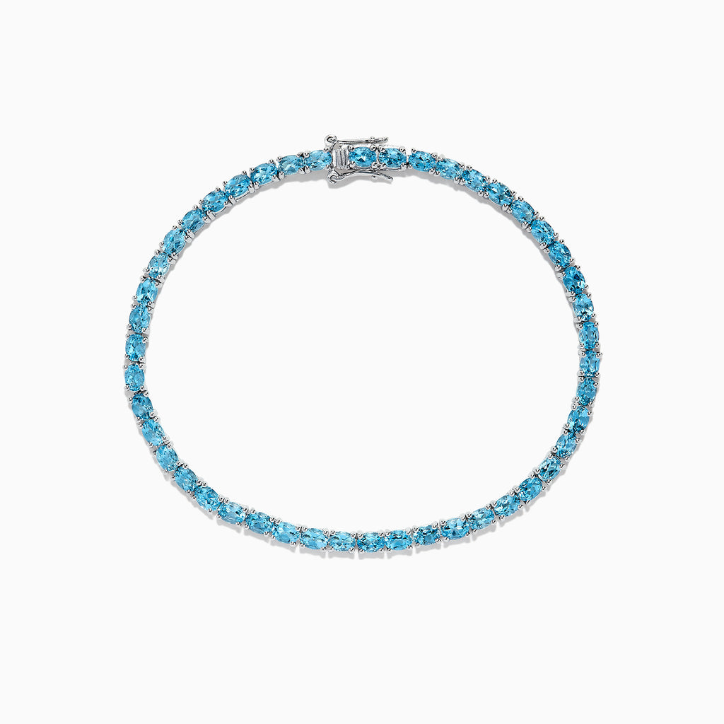 The 925 Sterling Silver Blue Topaz Tennis Bracelet, 9.55 TCW, is shown in a circular shape on a white background, featuring a continuous row of round blue topaz gemstones.
