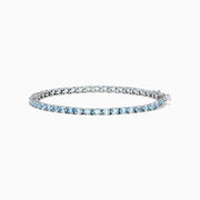 The 925 Sterling Silver Aquamarine Tennis Bracelet showcases a row of round aquamarine stones in prong settings, elegantly displayed against a plain white background.