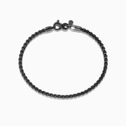 The Mens 925 Sterling Silver Black Rhodium Box Chain Bracelet features a lobster clasp and is displayed in a circular shape on a white background.