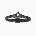 The Mens Sterling Silver Black Rhodium Braided Chain Blue Sapphire Bracelet 1.40 TCW features a square centerpiece set with blue sapphires and a round clasp, shown on a white background.