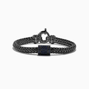 The Mens Sterling Silver Black Rhodium Braided Chain Blue Sapphire Bracelet 1.40 TCW features a square centerpiece set with blue sapphires and a round clasp, shown on a white background.