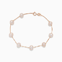 The 14K Rose Gold Blush Freshwater Pearl Bracelet features evenly spaced white freshwater pearls on a delicate rose gold chain, secured with a small spring ring clasp and displayed on a plain white background.
