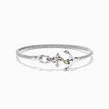 The Seaside Sterling Silver & 18K Gold Anchor Bangle features a twisted cable design, an anchor-shaped clasp, and rope detail for a nautical touch, showcased on a white background.