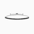 The 14K White Gold Black Diamond Bolo Bracelet features a row of round black diamonds set in a single line, secured with a sliding clasp and accented by two bead ends on the chain.