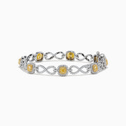 The Canare 14K Two Tone Gold Yellow and White Diamond Infinity Tennis Bracelet, 3.34 TCW, features an intricate infinity pattern set with yellow gemstones framed by diamonds and a secure right-side clasp.