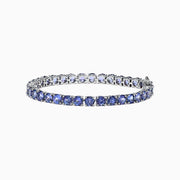 The Nahla Siri Sterling Silver Tanzanite Tennis Bracelet, 15.60 TCW, features a single row of round tanzanite gemstones set in prongs, shown on a white background.