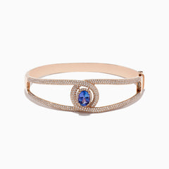 The Nahla Siri 14K Rose Gold Tanzanite and Diamond Bangle, 3.76 TCW, features a central oval tanzanite encircled by white diamonds and additional diamonds along its elegant openwork band.