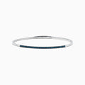 The Bella Bleu 14K White Gold Blue Diamond Bangle showcases a slim white gold design accented with brilliant blue diamonds, offering an elegant sparkle to any ensemble.