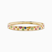 The Watercolors 14K Yellow Gold Multi Sapphire Bangle features sapphires in pink, green, blue, and yellow shades arranged in a scattered design around the band.