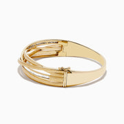The DOro 14K Brushed Yellow Gold Diamond Crossover Bangle (1.10 TCW) features overlapping polished and textured bands in a crossover design, complete with a subtle side clasp for a refined finish.