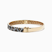 The Signature 14K Yellow Gold Diamond Panther Spot Bangle showcases a leopard print with black, brown, and white stones and an elegant openwork interior design.