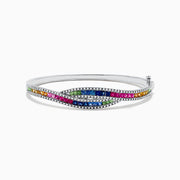 The 14K White Gold Multi Sapphire and Diamond Bangle showcases wavy rows of pink, blue, green, orange, and clear gemstones in an intricate and sparkling pattern for a vibrant look.