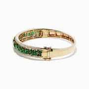 The Brasilica 14K Yellow Gold Emerald and Diamond Bangle, 6.81 TCW, features a secure clasp, elegant design, and is adorned with an intricate row of emeralds and small diamonds.