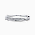 The 14K White Gold Diamond Cross Over Bangle, 1.05 TCW, features intertwined bands with dazzling diamonds, beautifully displayed on a white background.