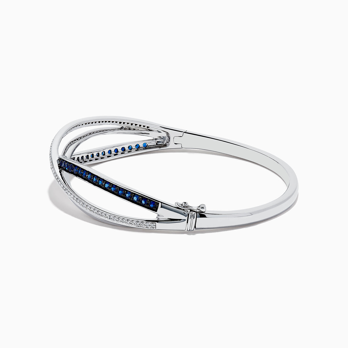 The Royale Bleu 14K White Gold Blue Sapphire and Diamond Crossover Bangle showcases a modern, elegant design with sparkling diamonds and a row of blue sapphires for a sophisticated accessory.