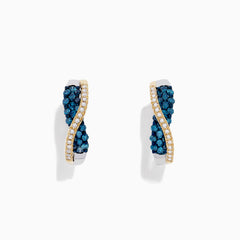 The 14K Two Tone Gold Blue and White Diamond Crossover Hoop Earrings, 1.00 TCW, feature a wavy crossover design with blue and white diamond clusters on one side and a line of small clear stones, shown against a white background.