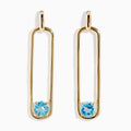 14K Yellow Gold Paperclip Blue Topaz Drop Earrings feature a minimalist, elongated design, each adorned with a round blue topaz at the bottom for effortless elegance.