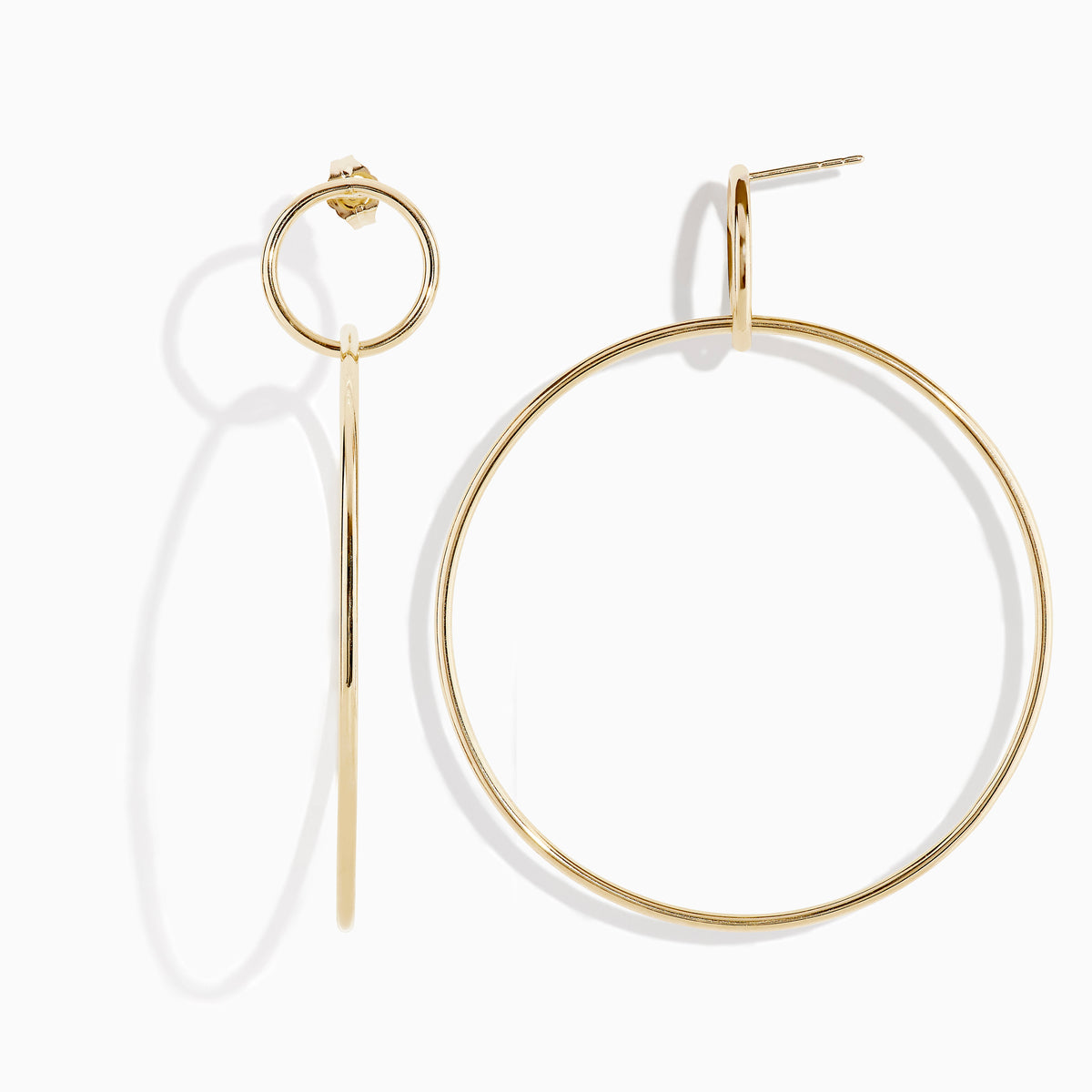 A pair of 14K Yellow Gold Double Circle Drop Earrings, one shown from the side and the other from the front, both displaying minimalist circular designs against a white background.