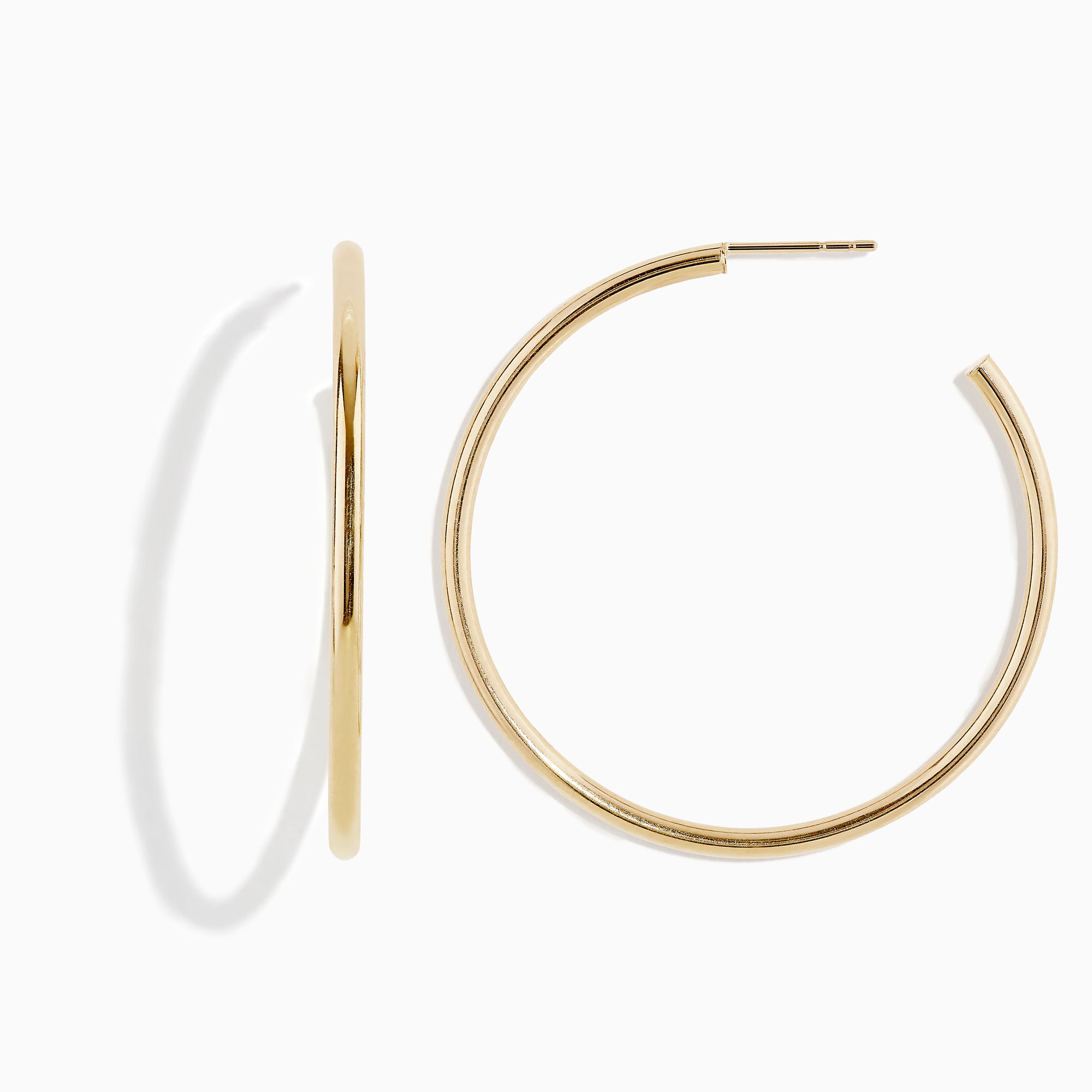 The 14K Yellow Gold Round Tube Open Hoop Earrings are shown on a white background—one upright to highlight the circular design, the other laid flat to showcase thickness and clasp detail.