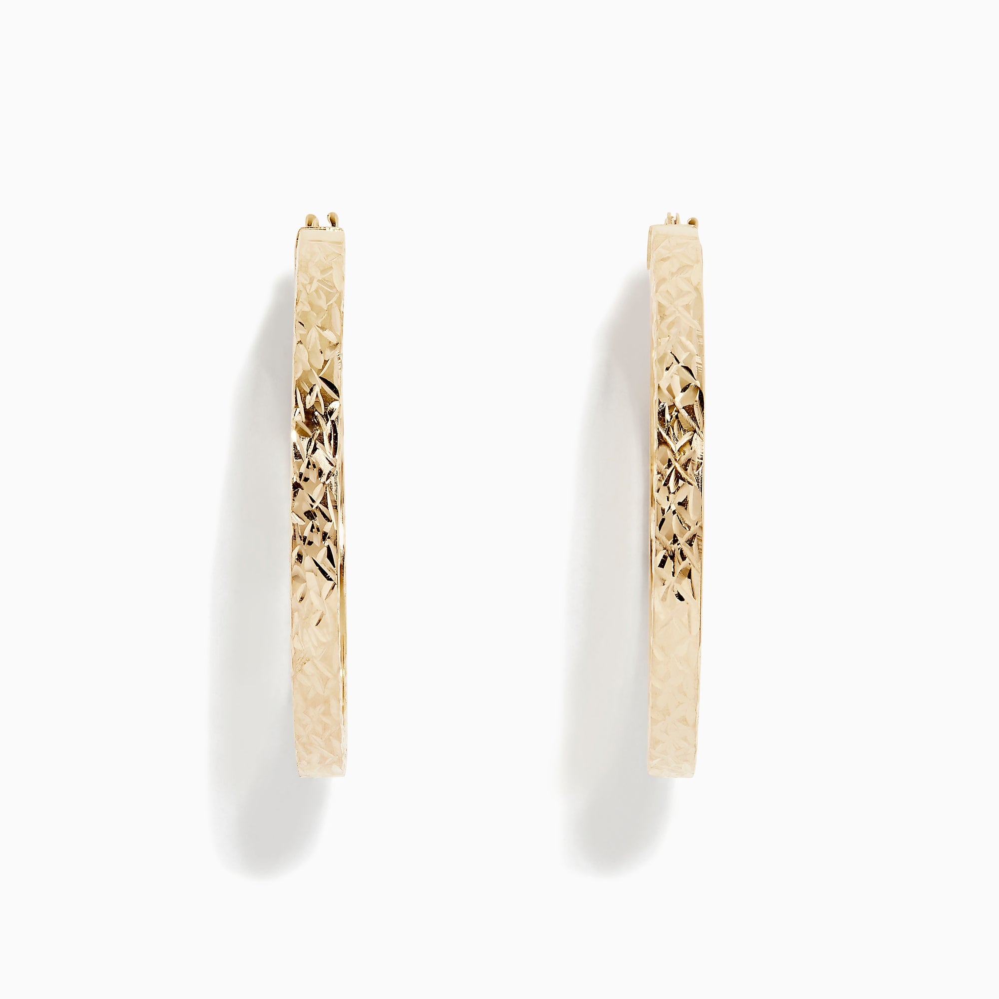 The 14K Yellow Gold Tube Hoop Earrings feature a diamond-patterned, textured surface, latch closures, and are shown with one earring from the front and one from the side.