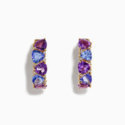 A pair of 14K yellow gold hoop earrings featuring alternating amethyst, tanzanite, and sparkling diamonds, displayed vertically on a white background.