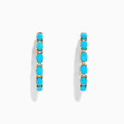 A pair of 14K Yellow Gold Turquoise Hoop Earrings, 3.95 TCW, featuring evenly spaced bright turquoise stones, displayed against a plain white background.