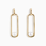 The 14K Yellow Gold Paperclip Cultured Freshwater Pearl Earrings feature elongated oval hoops in yellow gold, each adorned with a single freshwater pearl at the bottom, displayed on a plain white background.