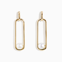 The 14K Yellow Gold Paperclip Cultured Freshwater Pearl Earrings feature elongated oval hoops in yellow gold, each adorned with a single freshwater pearl at the bottom, displayed on a plain white background.