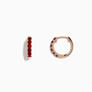 The Ruby Royale 14K Rose Gold Ruby Huggie Earrings (0.57 TCW) feature vibrant red rubies set in small rose gold hoops by Effy, shown against a white background.