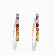 The Watercolors 14K Yellow Gold Multi Sapphire 1 Hoop Earrings (6.18 TCW) feature a rainbow arrangement of sapphires and are shown against a white background with a subtle shadow.