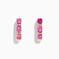 A pair of 14K rose gold huggie hoop earrings featuring pink sapphires and diamonds, displayed against a white background.