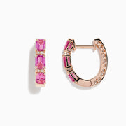 A pair of 14K rose gold huggie hoop earrings featuring pink sapphires and diamonds, displayed against a white background.