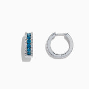 Bella Bleu 14K White Gold Hoop Earrings, 0.92 TCW, showcase a central row of blue and white diamonds bordered by small clear stones, presented against a white background.