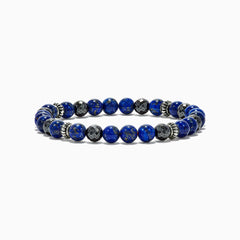 The Mens Lapis Lazuli and Hematite Beaded 7.5 Bracelet features round blue lapis lazuli stones, faceted hematite beads, and silver spacers on an elastic band, totaling 60.00 TW, displayed against a white background.