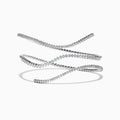 The Pave Classica 14K White Gold Diamond Wrap Bracelet, 3.43 TCW, coils elegantly in midair against a white background, casting a soft shadow and showcasing round-cut diamonds set closely along its length.